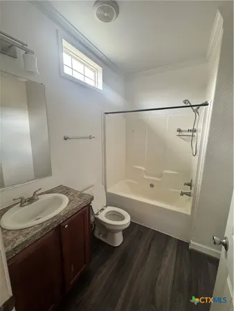 a bathroom with a granite countertop sink a toilet a mirror and bathtub