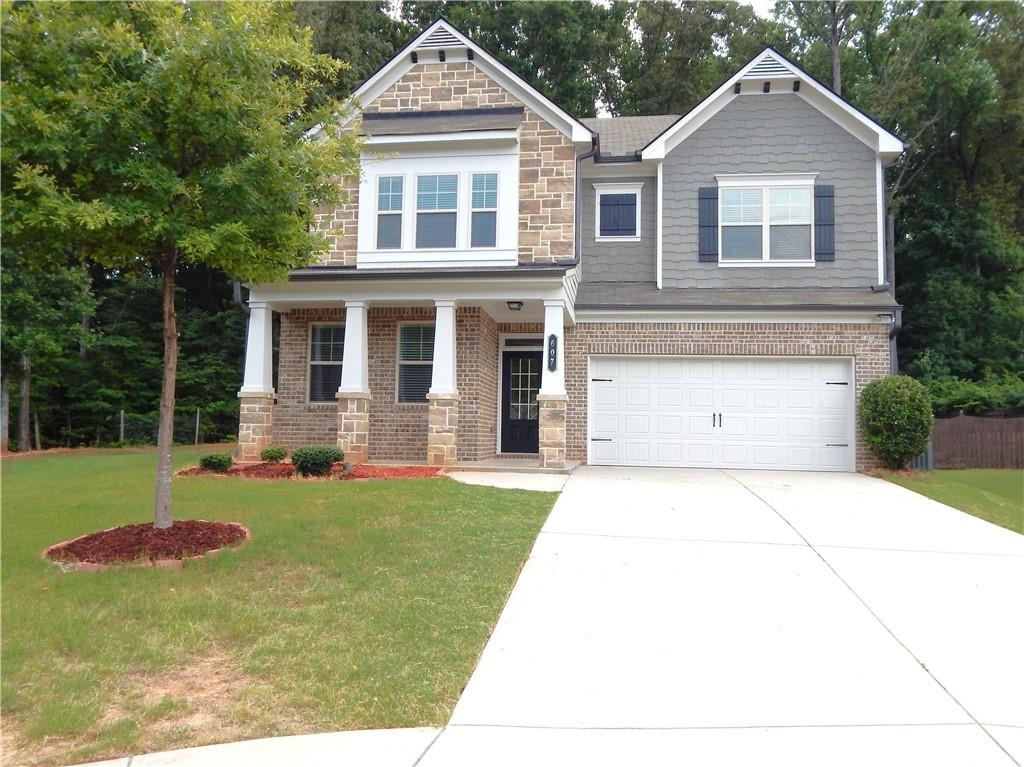607 Paden Ridge Way Lawrenceville, GA 30044 - Photo 1 of 1 a front view of a house with a yard and garage