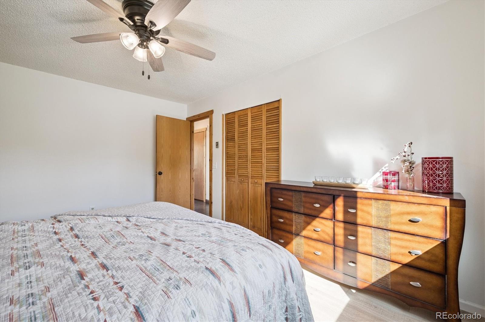 12369 Quartz Spur Conifer, CO 80433 - Photo 14 of 36 a bedroom with a bed and a chandelier