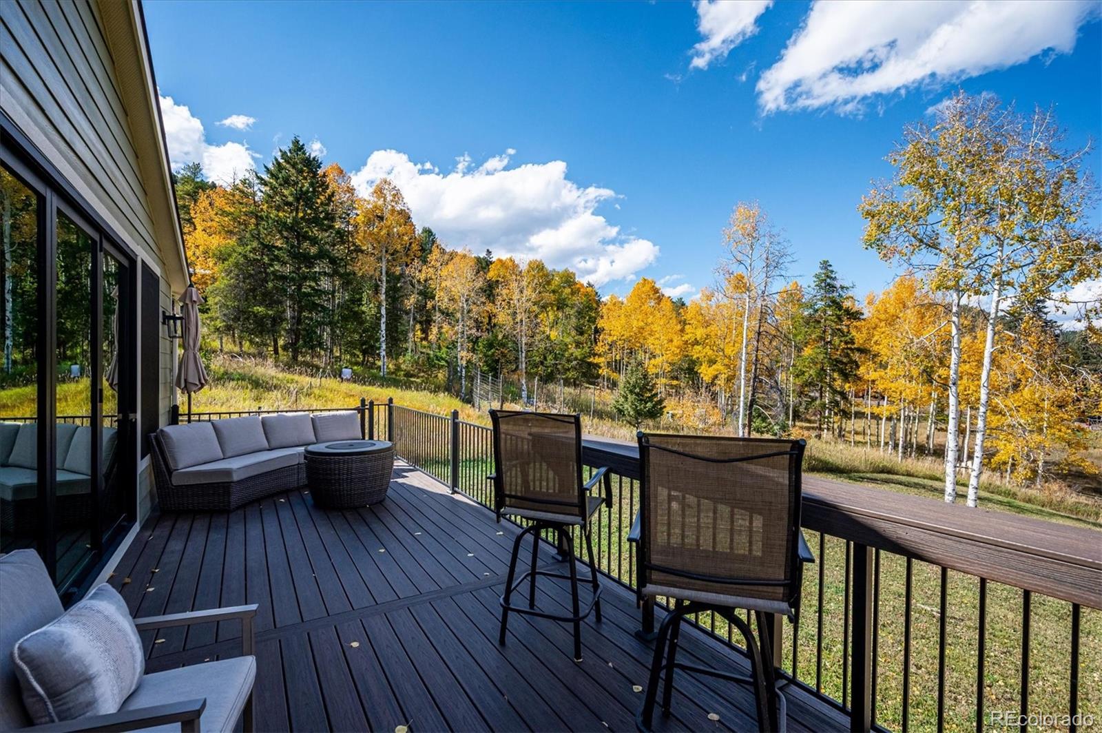 12369 Quartz Spur Conifer, CO 80433 - Photo 25 of 36 a view of a balcony with wooden floor and outdoor seating