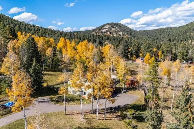 an aerial view of residential house with swimming pool and lawn chairs