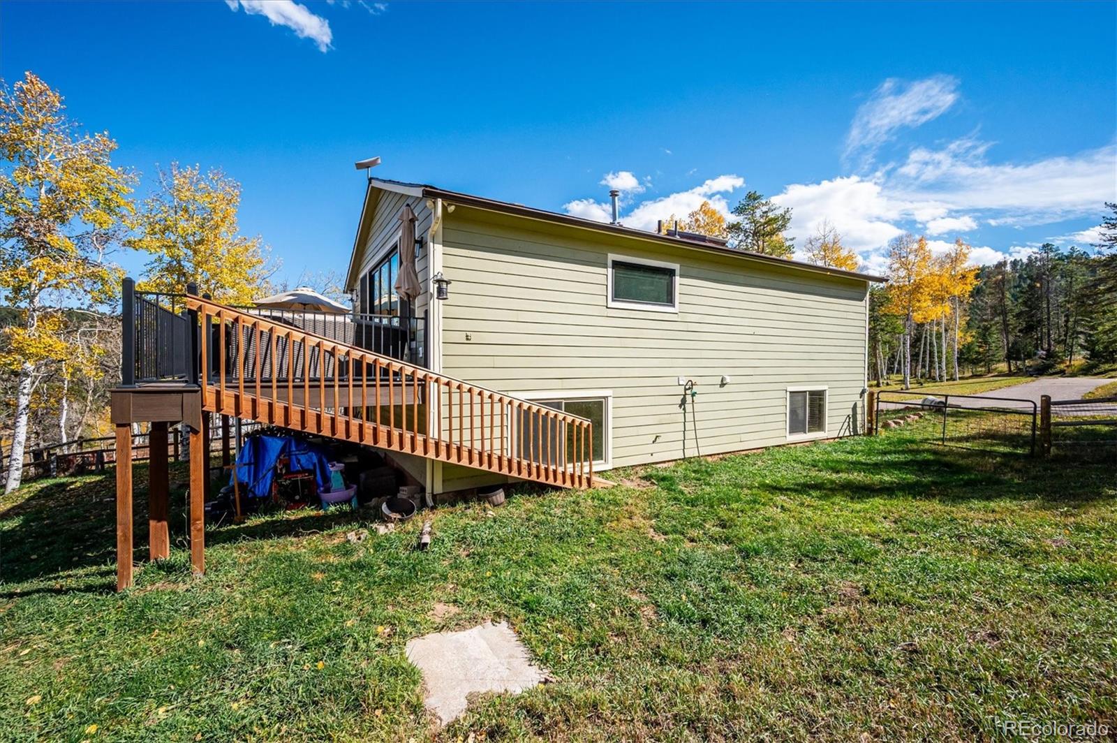 12369 Quartz Spur Conifer, CO 80433 - Photo 35 of 36 a view of a house with a yard and deck