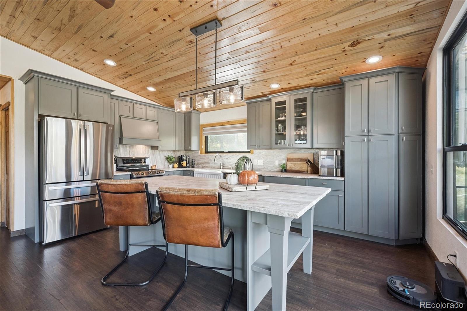 12369 Quartz Spur Conifer, CO 80433 - Photo 8 of 36 a kitchen with a refrigerator a stove dining table and chairs