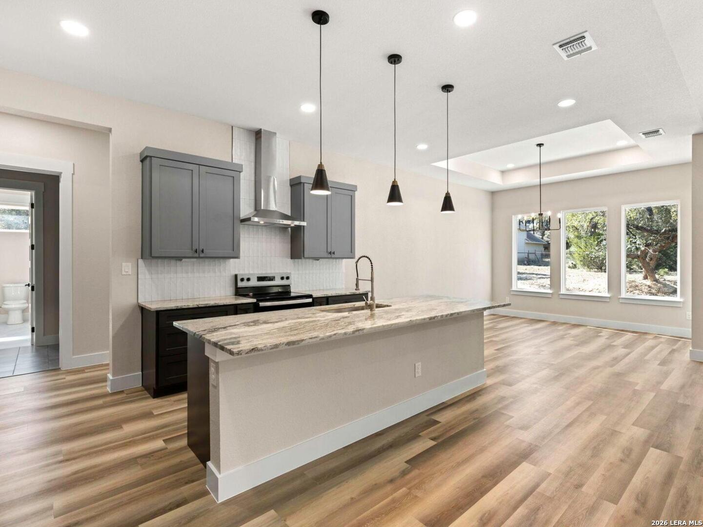 1270 Misty Lane Spring Branch, TX 78070 - Photo 14 of 48 a large kitchen with stainless steel appliances granite countertop a stove a sink a refrigerator and a wooden floor