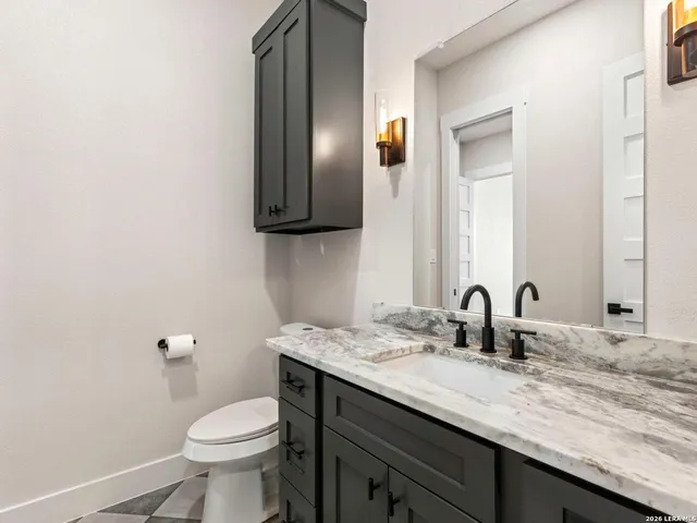 a bathroom with a toilet sink and mirror