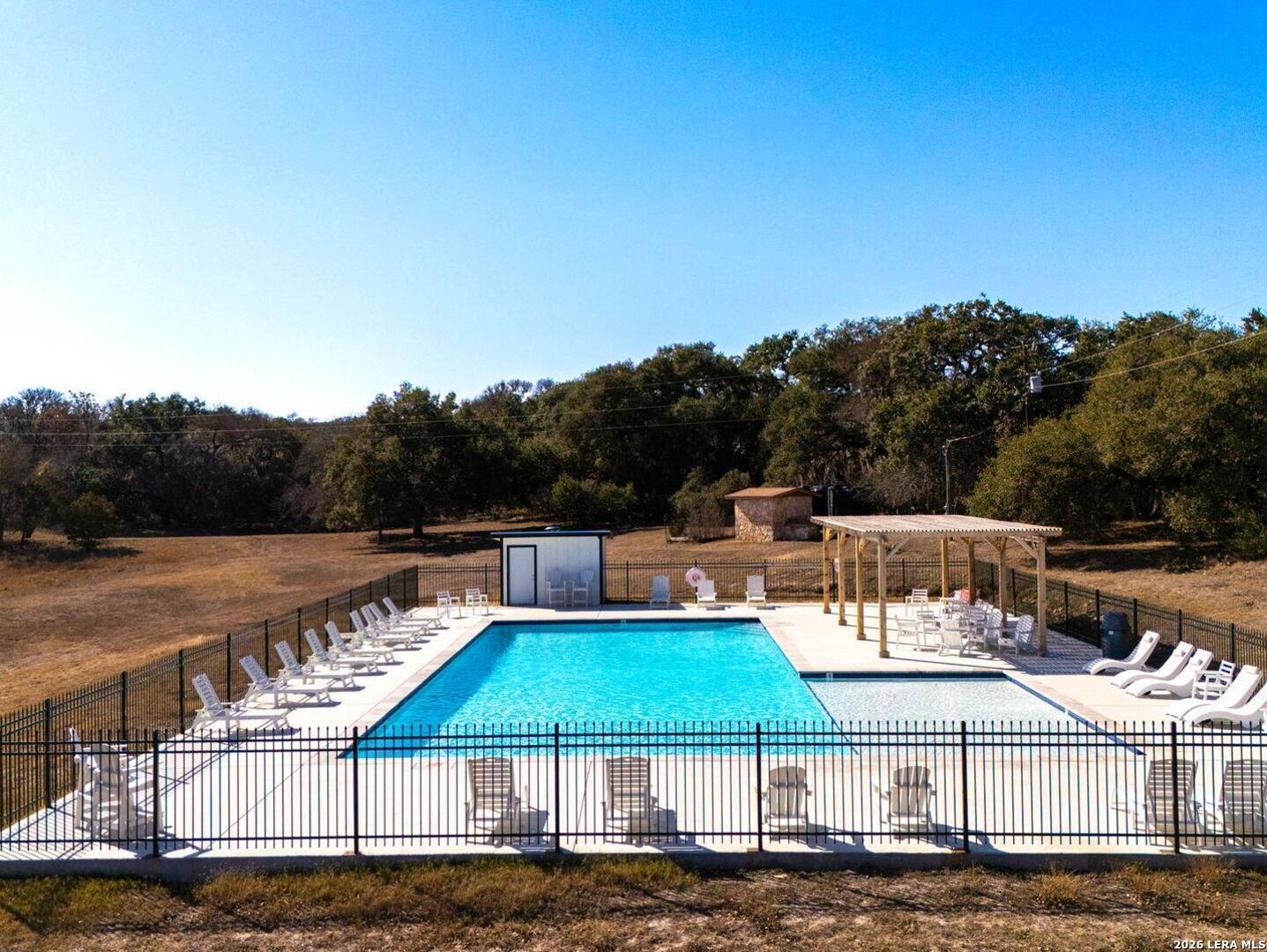 1270 Misty Lane Spring Branch, TX 78070 - Photo 39 of 48 a view of a patio with lawn chairs under an umbrella with large trees