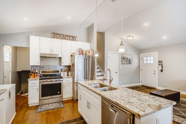 a kitchen with granite countertop a sink stove and refrigerator