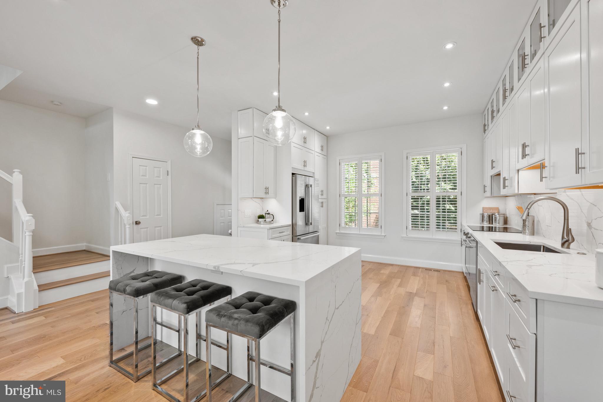 3604 Winfield Lane Northwest Washington, DC 20007 - Photo 11 of 35 a large kitchen with granite countertop a stove a sink a refrigerator and a dining table with wooden floor