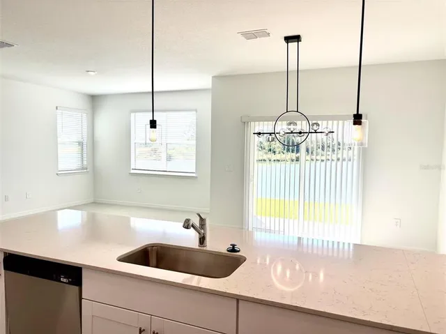 a kitchen with a sink a window and wooden floor