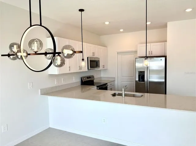 a kitchen with kitchen island a sink and a wooden floor