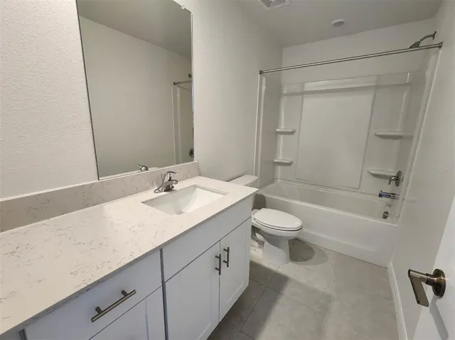 a bathroom with a granite countertop sink a toilet and shower