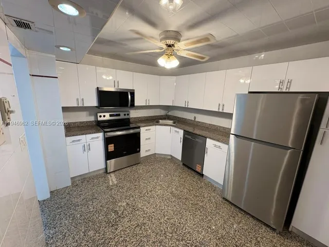 a kitchen with a refrigerator a sink and a stove top oven