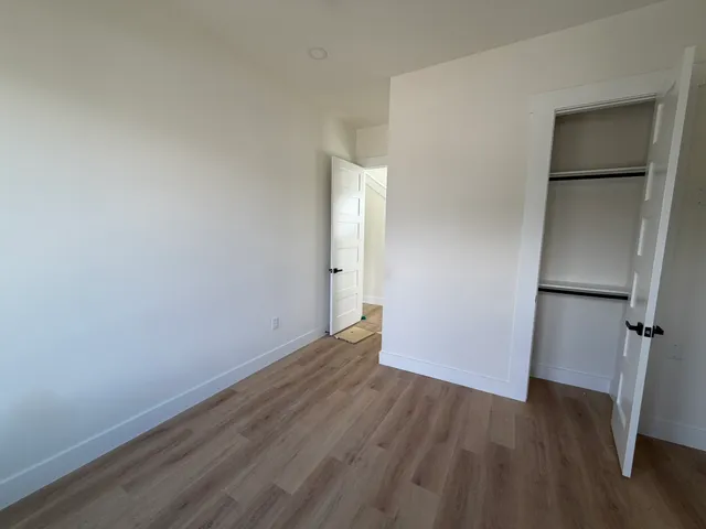 a view of a balcony with wooden floor and cabinets