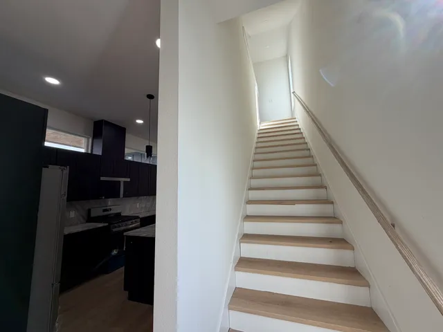 an empty room with wooden floor ceiling fan and windows