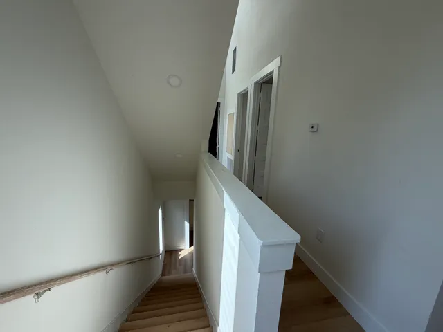 a view of a livingroom with wooden floor and a ceiling fan