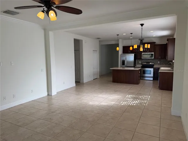 a view of kitchen with stainless steel appliances kitchen island granite countertop a refrigerator a stove top oven a sink and dishwasher