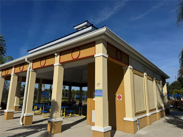 a view of a swimming pool with lawn chairs under an umbrella