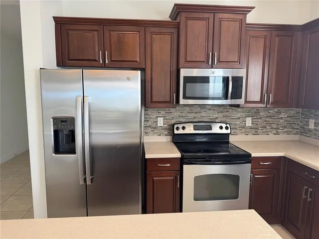a kitchen with stainless steel appliances granite countertop a refrigerator stove and sink