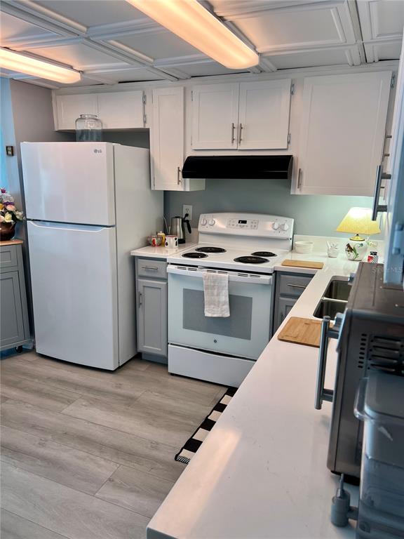 9951 Southwest 88th Court Road, Unit G Ocala, FL 34481 - Photo 11 of 38 a kitchen with a stove a refrigerator and a sink