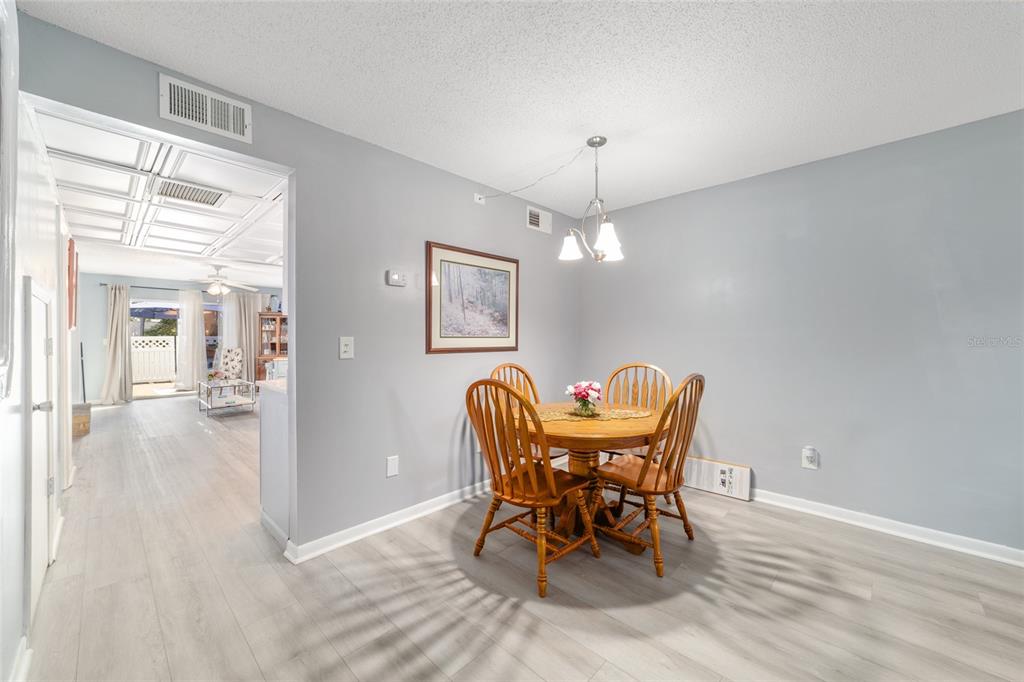 9951 Southwest 88th Court Road, Unit G Ocala, FL 34481 - Photo 14 of 59 a dining room with furniture a chandelier and wooden floor