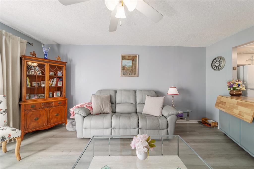 9951 Southwest 88th Court Road, Unit G Ocala, FL 34481 - Photo 29 of 59 a living room with furniture and painting on the wall