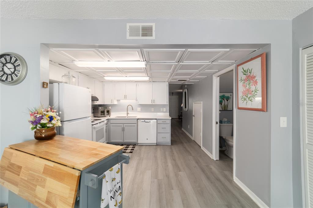 9951 Southwest 88th Court Road, Unit G Ocala, FL 34481 - Photo 30 of 59 a kitchen with a refrigerator a sink dishwasher with a dining table and chairs