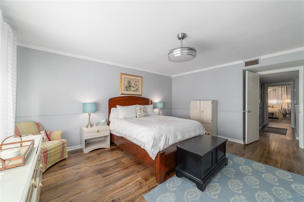 9951 Southwest 88th Court Road, Unit G Ocala, FL 34481 - Photo 35 of 59 a bedroom with a bed and wooden floor
