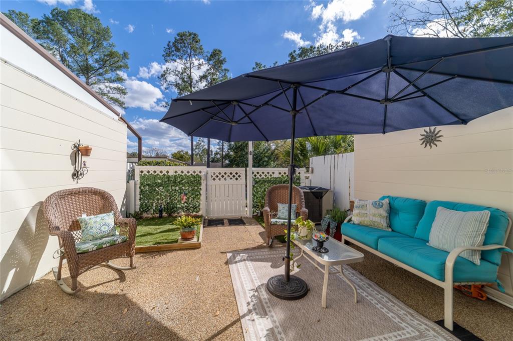 9951 Southwest 88th Court Road, Unit G Ocala, FL 34481 - Photo 49 of 59 a patio with a patio table and chairs