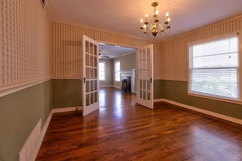 a view of a hallway with wooden floor and a chandelier