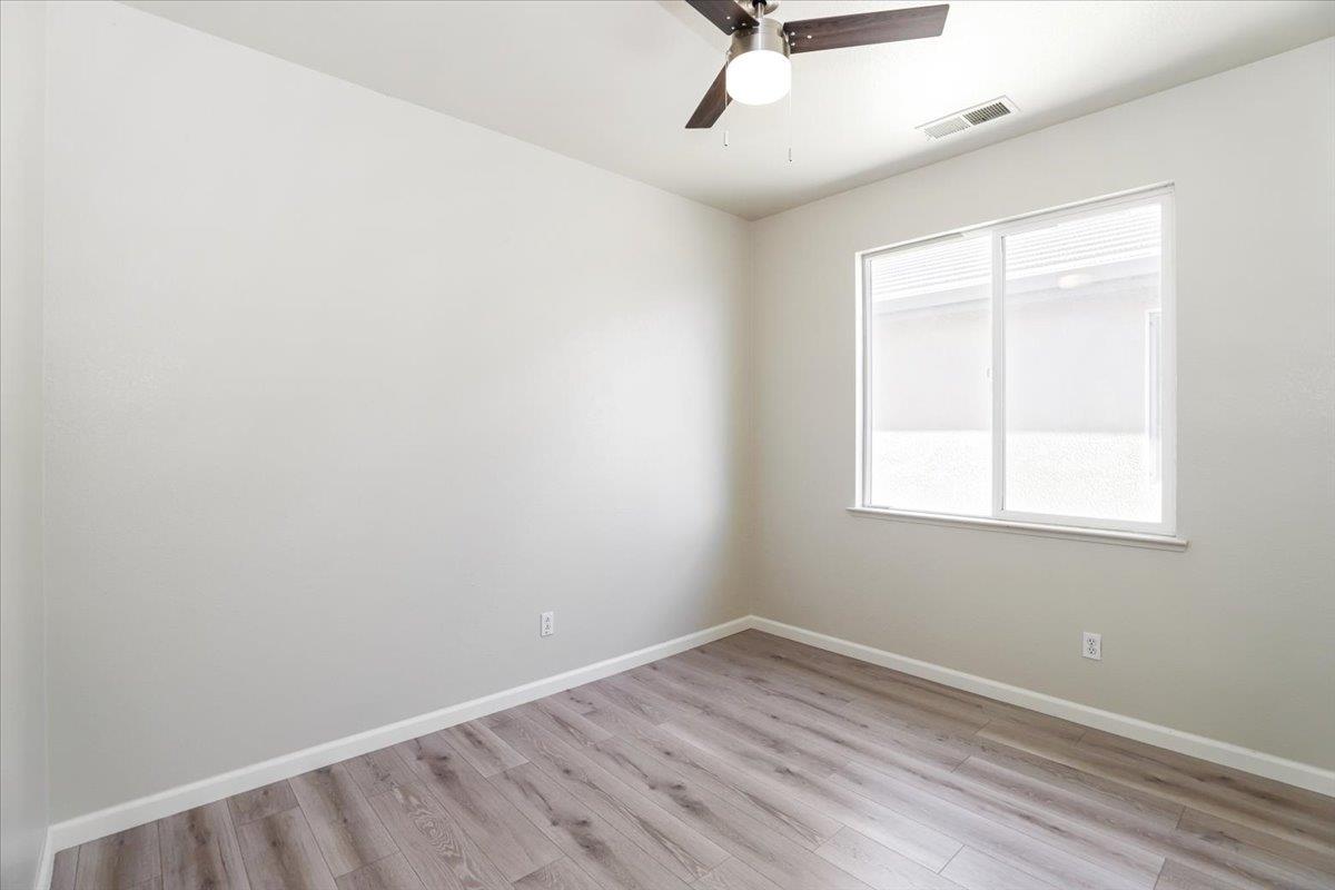 4467 Glenbrook Drive Tracy, CA 95377 - Photo 13 of 26 an empty room with a window and wooden floor