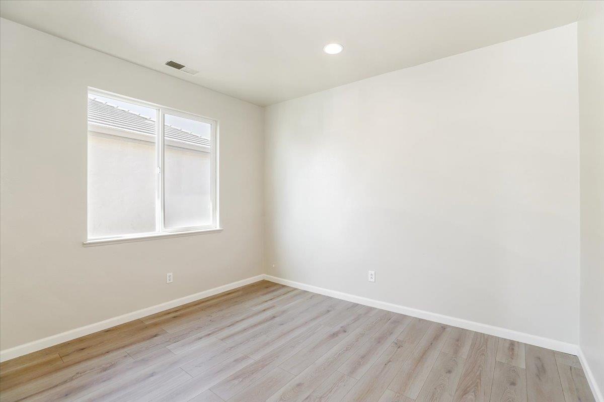4467 Glenbrook Drive Tracy, CA 95377 - Photo 18 of 26 a view of an empty room with wooden floor and a window