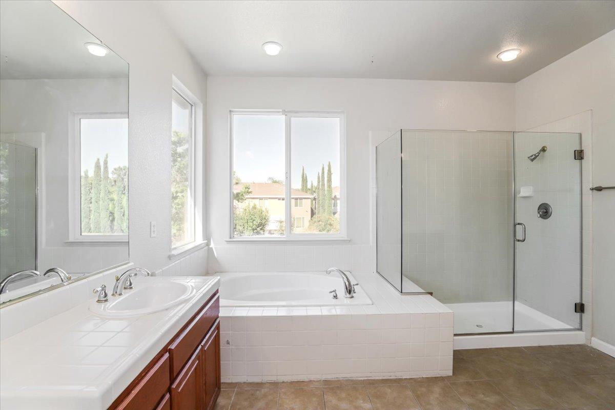 4467 Glenbrook Drive Tracy, CA 95377 - Photo 23 of 26 a bathroom with a tub sink and mirror