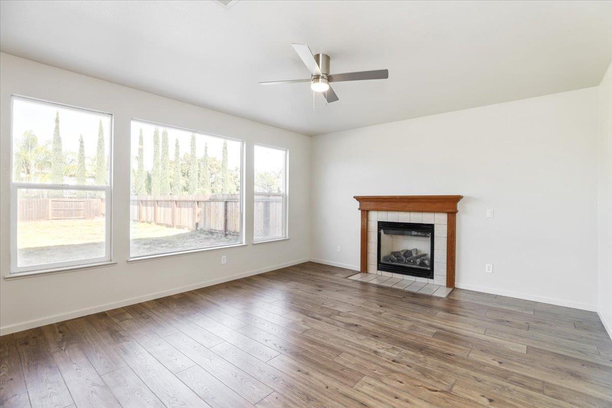 4467 Glenbrook Drive Tracy, CA 95377 - Photo 9 of 26 an empty room with wooden floor fireplace and windows