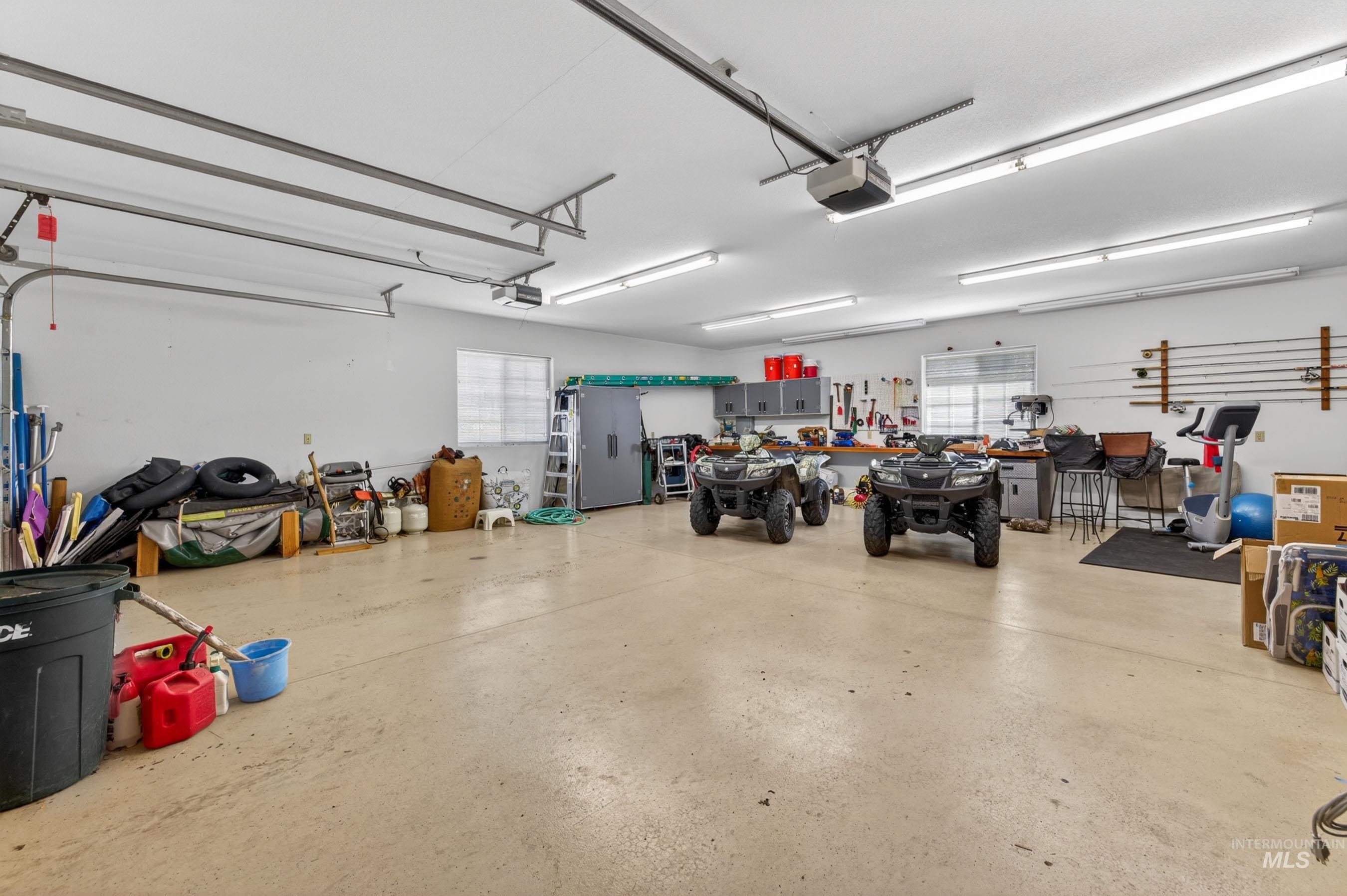 113 Deford Road White Bird, ID 83554 - Photo 39 of 49 Spacious garage featuring concrete flooring, multiple windows, built-in cabinetry, and overhead fluorescent lighting