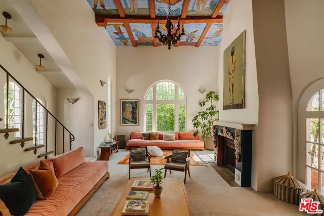 a living room with furniture a fireplace and a large window