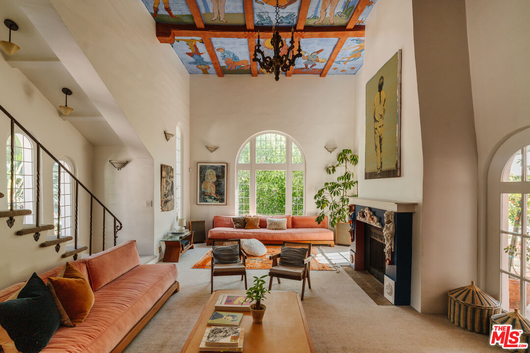 a living room with furniture a fireplace and a large window
