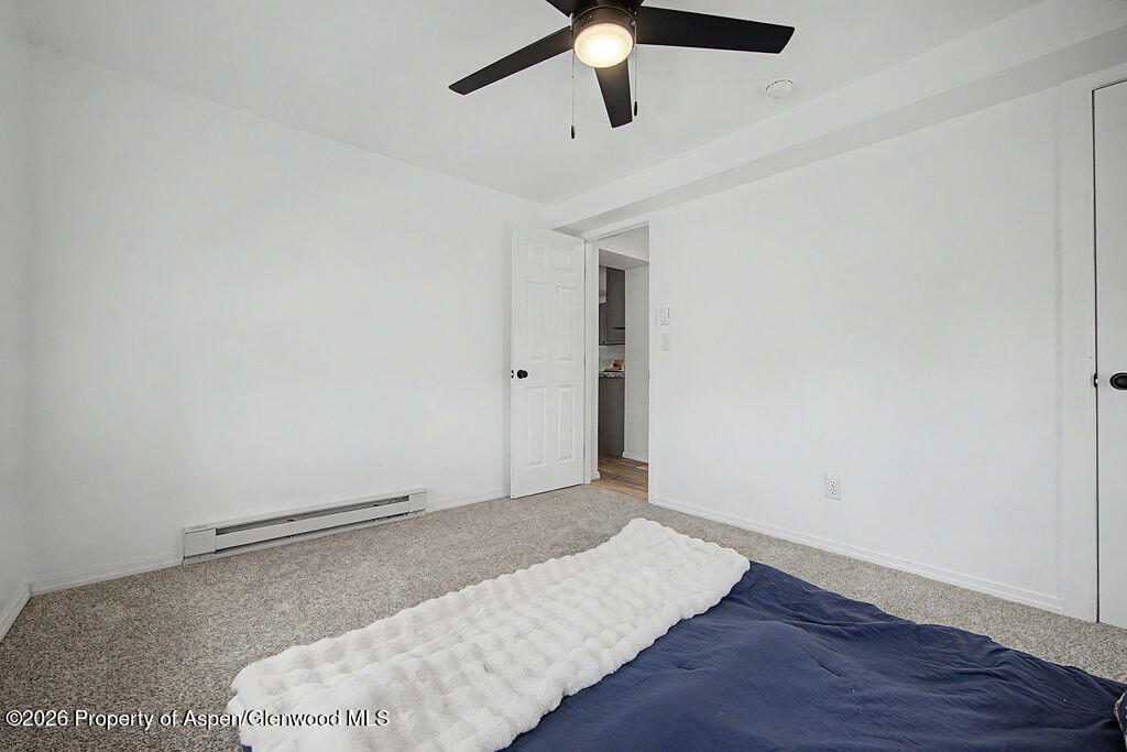 54 South Ranney Street Craig, CO 81625 - Photo 8 of 32 an empty room with wooden floor ceiling fan and window