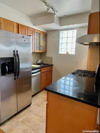 a kitchen with stainless steel appliances granite countertop a refrigerator a sink dishwasher a stove and a refrigerator