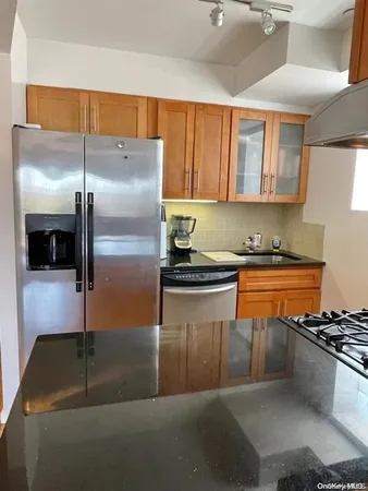 a kitchen with stainless steel appliances granite countertop a sink a stove and a refrigerator