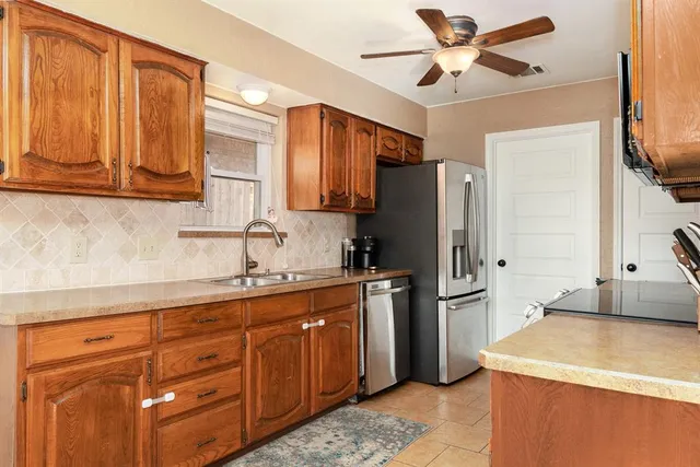 a kitchen with stainless steel appliances granite countertop a refrigerator a sink and dishwasher