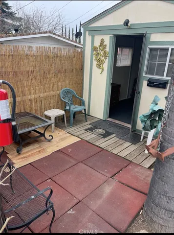 a view of a patio with table and chairs with barbeque grill and wooden fence