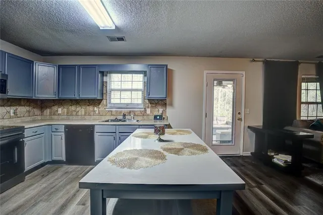 a kitchen with sink dining table and chairs