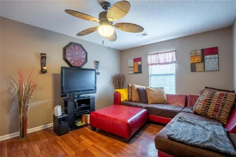 a living room with furniture a flat screen tv and a window