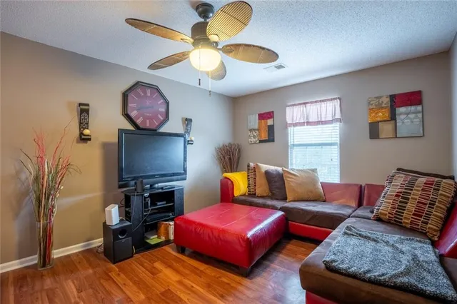 a living room with furniture a flat screen tv and a window