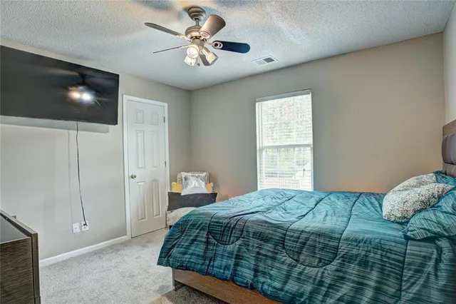 a bedroom with a bed and a painting on the wall