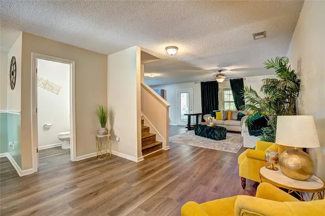 a living room with furniture and a wooden floor