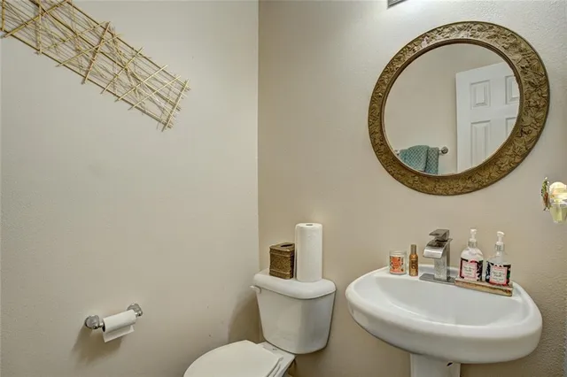 a bathroom with a toilet a sink and a mirror