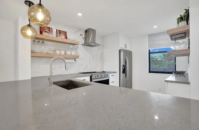 a living room with furniture chandelier and a view of kitchen appliances