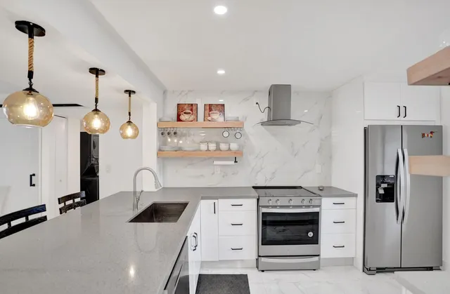 a living room with furniture kitchen view and a large window