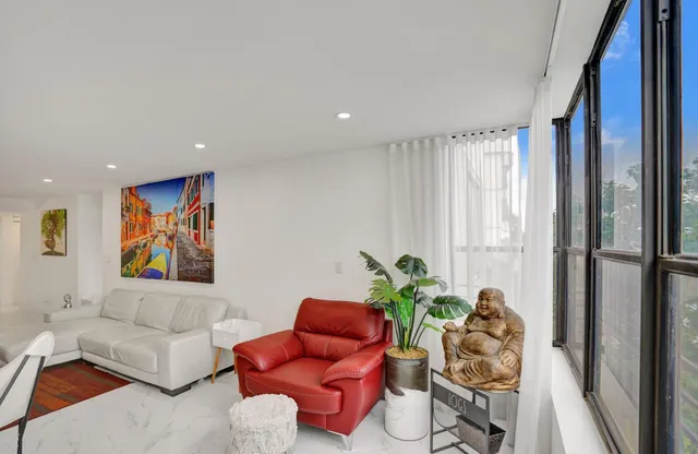 a view of a living room with furniture and floor to ceiling window
